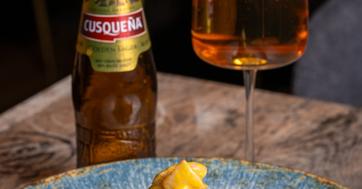 Plate of classic Peruvian ceviche on a wooden table at a Lima cevicheria with sweet potato, choclo, red onion, and a small glass of leche de tigre