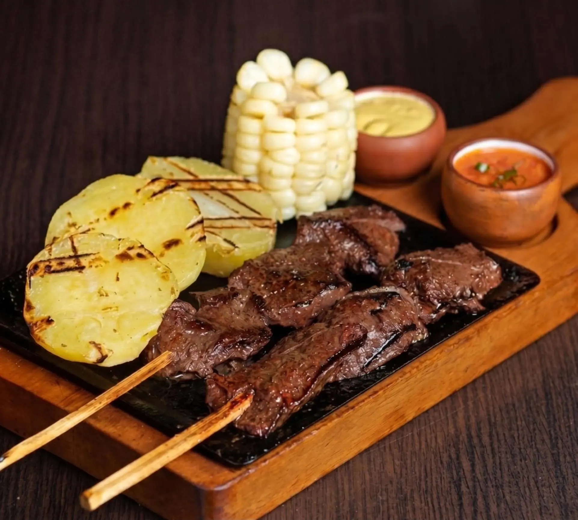 Anticucho skewers grilling on charcoal